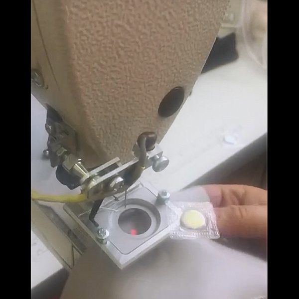 Automated solution for sewing on a laser-marked magnet